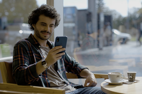 joven en sillón mirando el celular
